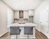 Kitchen with Island & Breakfast Bar • PLEASE NOTE: Photos are of a DIFFERENT Spec Home of the same model – fit and finish may differ. Interior selections and floorplans shown in photos. Kitchen appliances are included, and will be installed prior to possession.