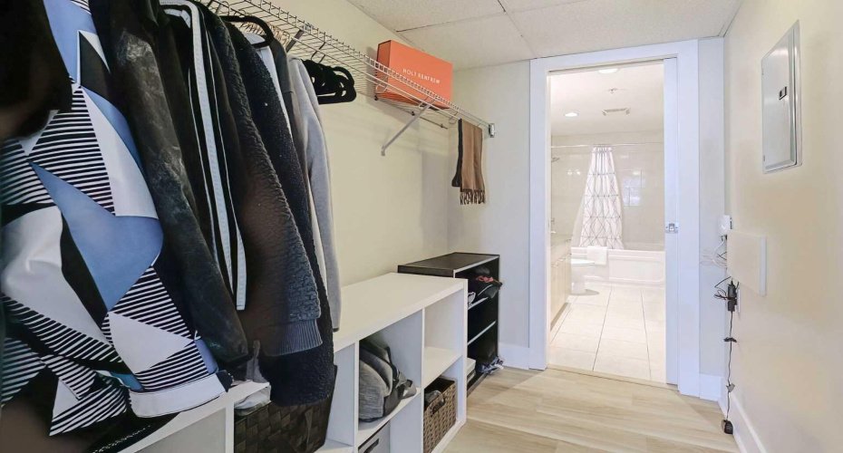 Walk-through closet with hanging bars on both sides and room for additional storage units.