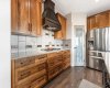 Premium stainless steel appliance package featuring a Bosch gas cooktop and custom Vent-A-Hood chimney hood fan...