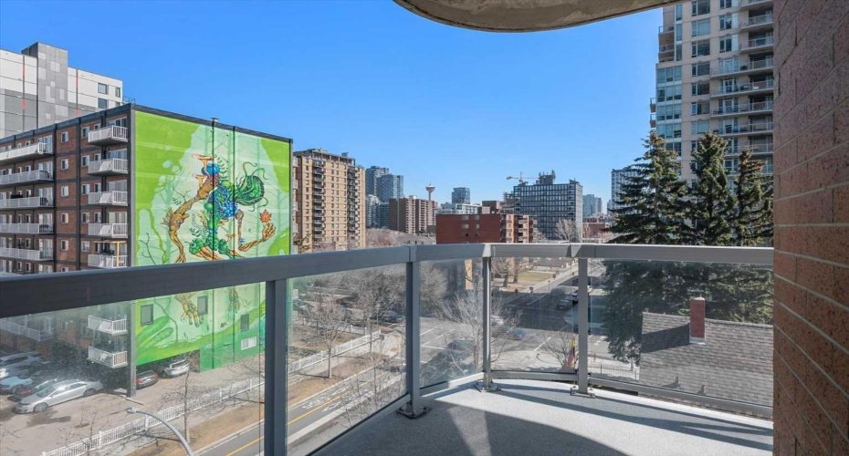 The balcony comes with a gas BBQ hookup and a downtown skyline to go with it. The Calgary Tower sits in the background, the mural is right there, and summer evenings on this terrace are hard to beat.