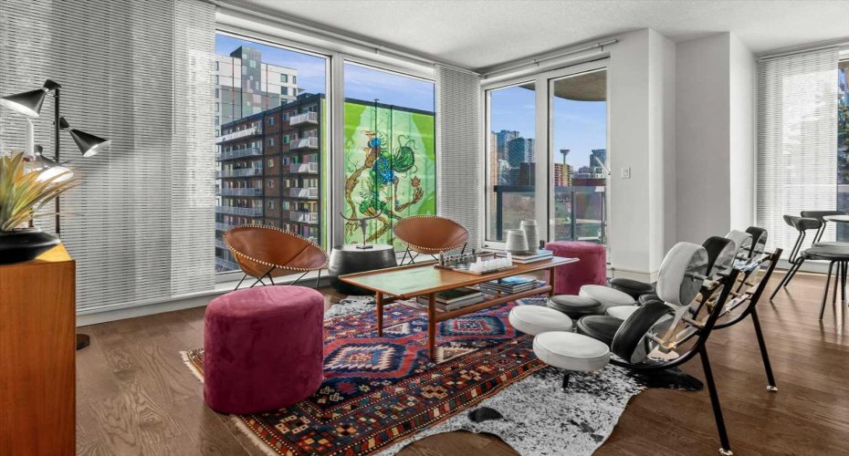 Two full walls of glass make this living room feel connected to the city in a way that standard layouts simply do not. The corner suite format is what makes this possible.