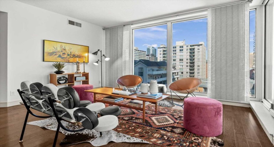 Nearly 900 square feet spread across a smart corner layout with hardwood floors and city views on two sides. The space lives larger than the number suggests.