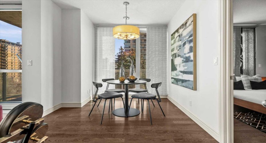 The dining area is tucked just off the main living space with its own window and a warm pendant overhead. It works equally well for a dinner party or a solo meal with a good podcast.
