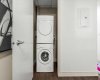In-suite stacked washer and dryer, tucked away in their own closet just off the entry. It is one of those things you do not think about until you are living somewhere that does not have it.