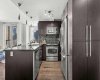 Espresso stained cabinetry, stainless steel appliances, and plenty of storage make this a kitchen people actually cook in. It handles a quiet Tuesday dinner just as well as a Saturday night with friends.