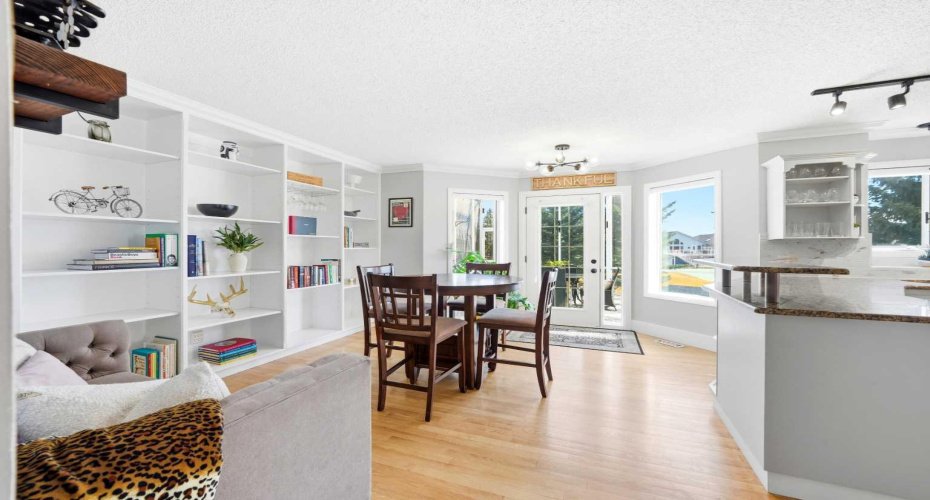 A light-filled breakfast nook with custom built-in wall shelving and seamless access to the screened-in deck.