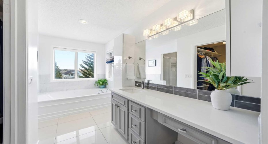 A stylishly updated primary ensuite with quartz countertops and a relaxing soaker tub.