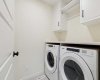 Upper level LARGE laundry room complete with ADDITIONAL BUILT-IN shelving & storage behind door!