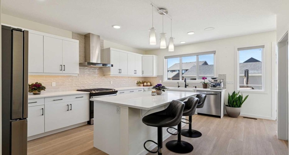 Your UPGRADED chef’s kitchen is a true showstopper, boasting gorgeous cabinetry, quartz countertops, designer tile, an oversized island, modern lighting,  beautiful farmhouse sink, high-end stainless steel appliances, motorized blinds, and large walk-in pantry, etc....