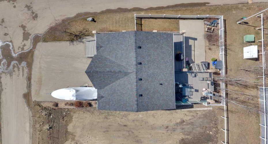 Overhead shot showing parking, side and rear yards, back deck, and greenspace behind.
