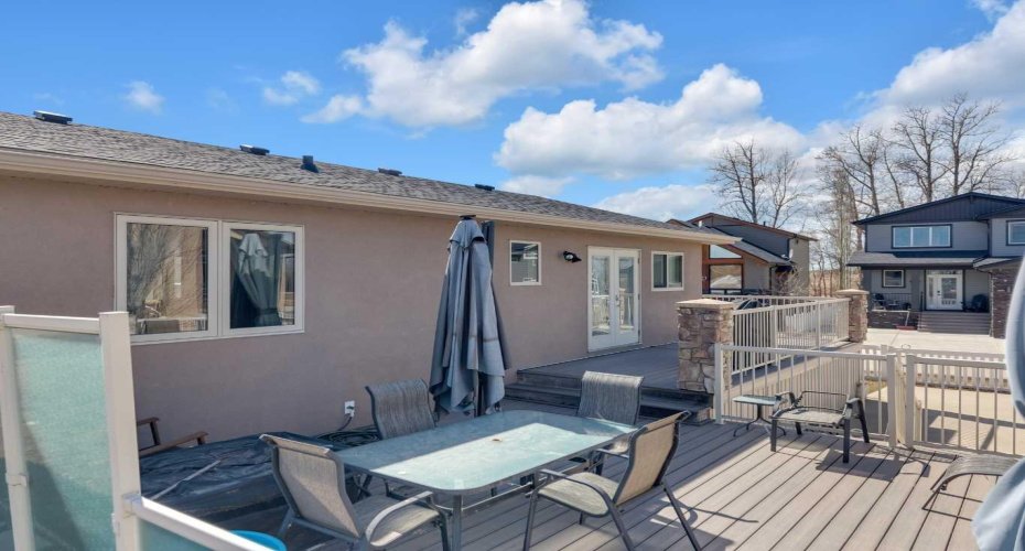 Multi-tiered deck with space for bbqing, lounging, and quick access to the back yard - all secured with fencing.