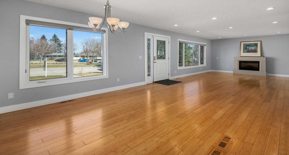 Massive front windows overlooking gardens and green space beyond.