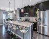 Kitchen features stainless steel appliances, timeless dark cabinets, new dishwasher, under cabinet lighting, island and pantry.