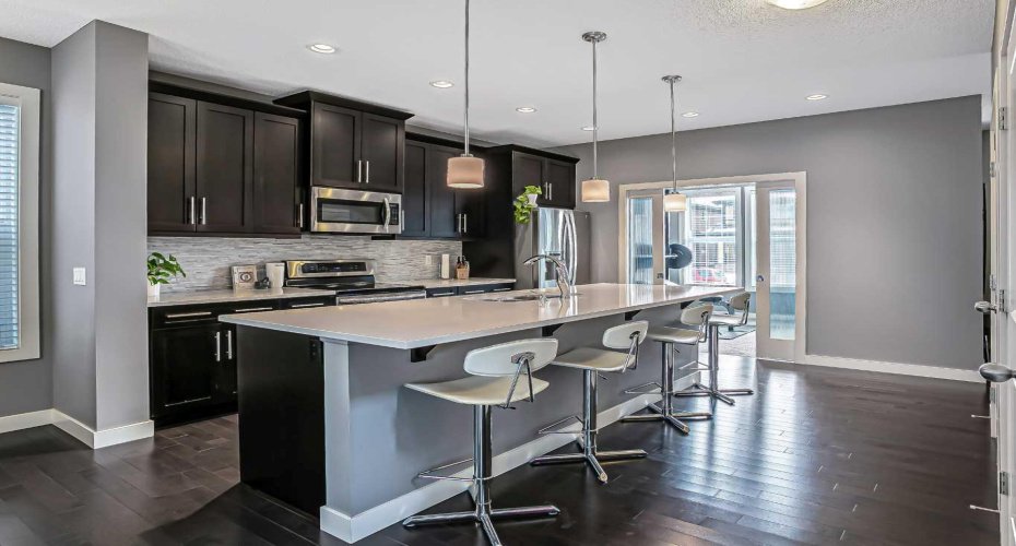 Kitchen features stainless steel appliances, timeless dark cabinets, new dishwasher, under cabinet lighting, island and pantry.