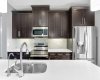 Kitchen features stainless steel appliances, timeless dark cabinets, new dishwasher, under cabinet lighting, island and pantry.