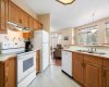 Kitchen, rectangular tile floor, white appliances, tile back splash.
