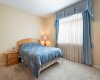 Primary bedroom, large window, drapes, curtains, venetian blind.