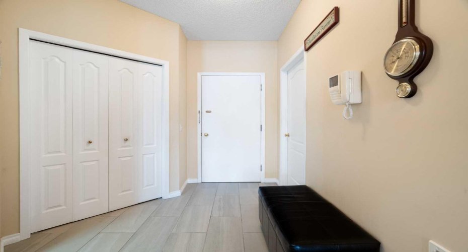 Entrance to 2107, spacious, rectangular tile floor, large entrance closet, laundry with storage on right.