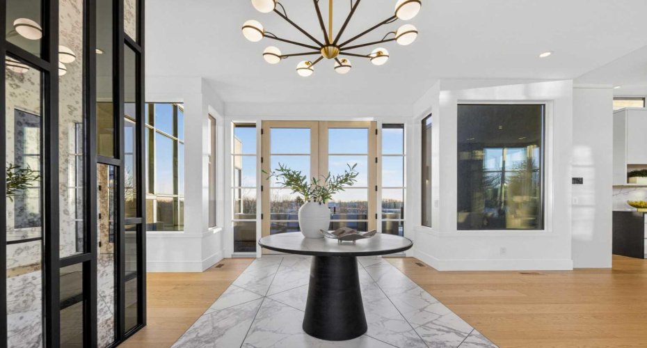 Foyer with double french doors at the end, leading to an expansive entertaining deck.