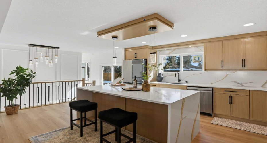 Showstopper kitchen with a waterfall island, quartz backsplash with seamless veins, premium built-in appliances, gas range with pot filler, glass cabinets, soft-close drawers, and smart WiFi appliances with a massive screen fridge.