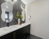 Spa-inspired 4-piece ensuite featuring full-height tile throughout—including side walls—dual vanity, designer fixtures, and a sleek modern finish.