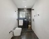 Custom-designed ensuite featuring a fully tiled shower with frameless glass, upgraded fixtures, and a premium smart toilet with automatic cleaning, heated seat, and bidet—delivering a true spa-like experience.