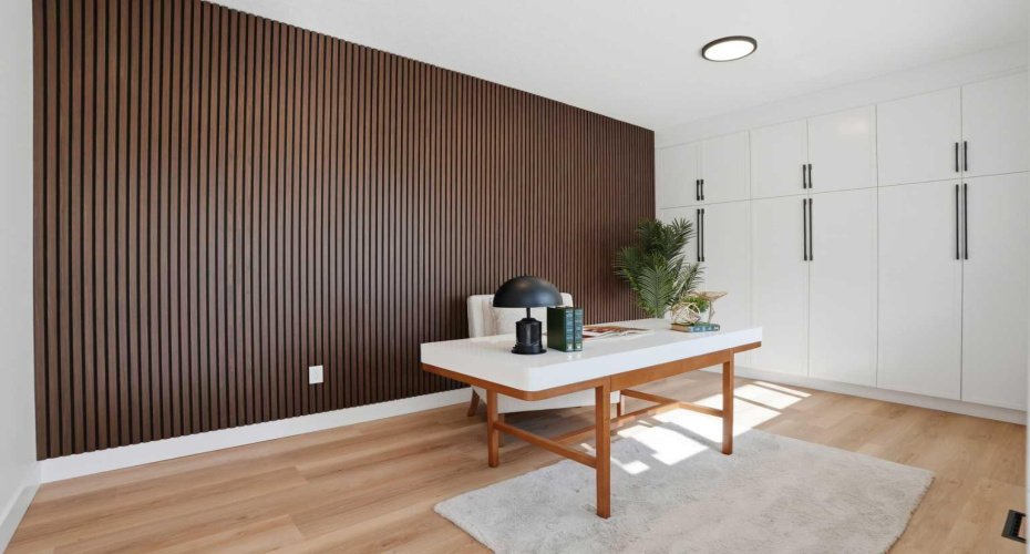 Bright multi-functional space with a large south-facing window, custom built-in cabinets for ample storage, and a designer feature wall—perfect as a bedroom or executive home office.