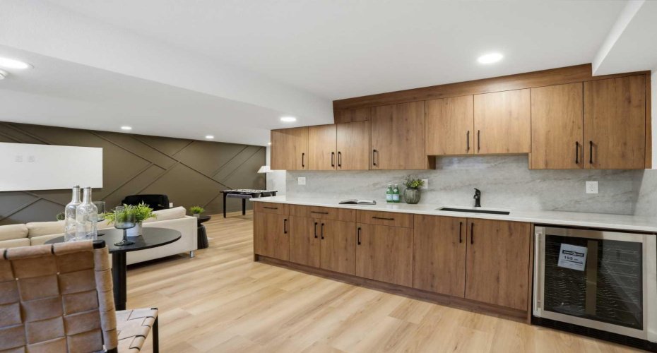 Designer wet bar showcasing premium Taj Mahal quartz with full-height backsplash, custom cabinetry, integrated sink, and a built-in beverage fridge—perfect for elevated entertaining.
