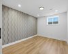 Well-appointed fourth bedroom with custom built-in cabinets, a stylish feature wall, and a clean, contemporary feel.
