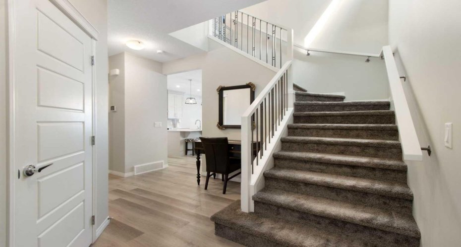 Stairs to upper level feature beautiful wood and metal railings