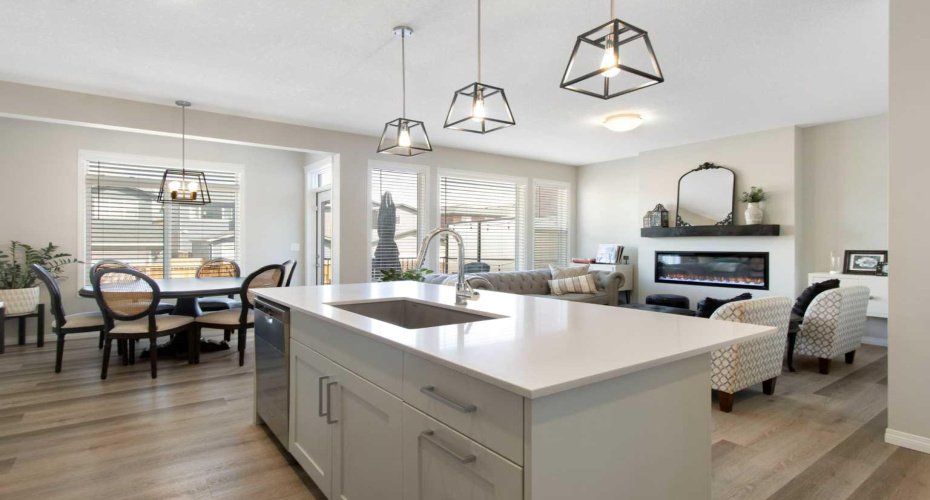 Beautiful kitchen features full height cabinets, induction range, quartz countertops and walkthrough pantry