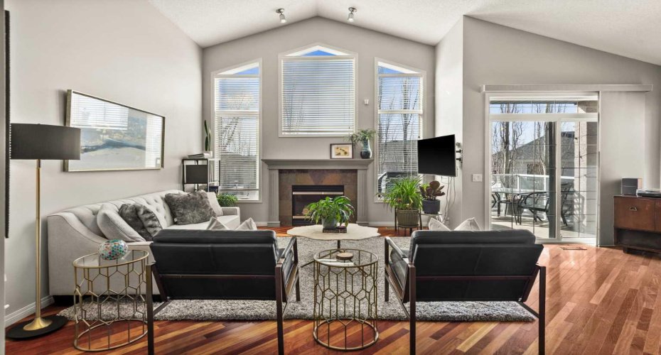 Bright living room anchored with natural gas fireplace, large southwest facing windows and vaulted ceilings.