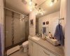 The upper-level main bathroom. Reimagined as a 4-piece retreat with a glass shower enclosure and dual shower heads.