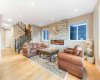 The spacious living room features west-facing windows that fill the space with natural sunlight...