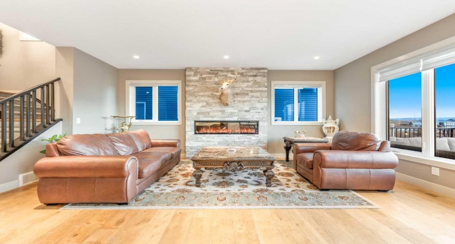 The spacious living room features west-facing windows that fill the space with natural sunlight...