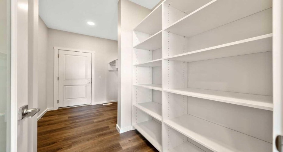 Walk-through mud room and pantry with shelves & benches.
