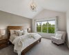 The spacious primary suite offers a peaceful escape, complete with vaulted ceilings, abundant natural light, and tranquil views overlooking the river valley with glimpses of the Rockies in the west.
