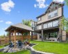 The fully finished walkout home offers exceptional indoor-outdoor living, highlighted by a covered upper deck, spacious lower patio, beautifully landscaped grounds, and direct access to the natural beauty of the Bow River valley beyond.