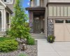 A warm and inviting entrance sets the tone for the home, featuring attractive stone accents, mature landscaping, and a covered front entry that creates a welcoming first impression for family and guests.