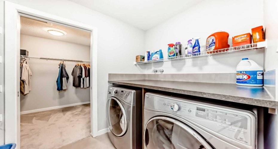 Upstairs laundry room that connects to the primary walk in closet