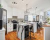 Contemporary white kitchen featuring quartz countertops, updated cabinetry (2024), and newer appliances including a Bosch dishwasher and induction stove.