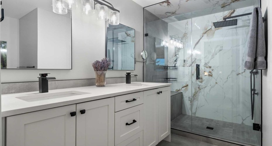 The beautifully renovated ensuite (2024) features dual vanities, heated floors, a spa-inspired shower, and a skylight that enhances the space with natural light.