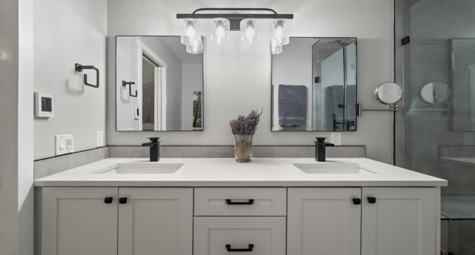 The beautifully renovated ensuite (2024) features dual vanities, heated floors, a spa-inspired shower, and a skylight that enhances the space with natural light.