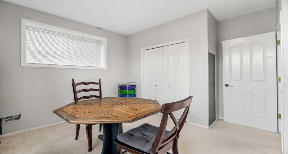 A spacious bedroom with two large windows overlooks the backyard