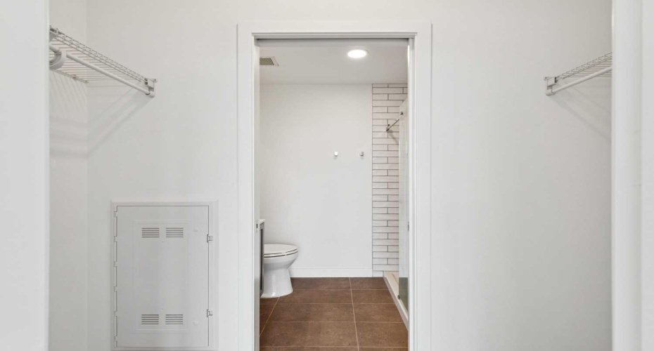 Walk-through closet in primary bedroom