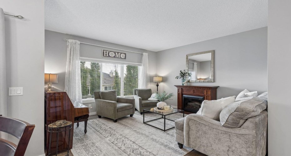 Settle into a space designed for slowing down and enjoying the moment. Large windows fill the living room with natural light, while the fireplace creates a warm focal point for cozy evenings, morning coffee, or quiet weekends at home.