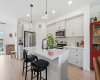 Anchor kitchen with large island, white quartz counter tops and sit up breakfast bar