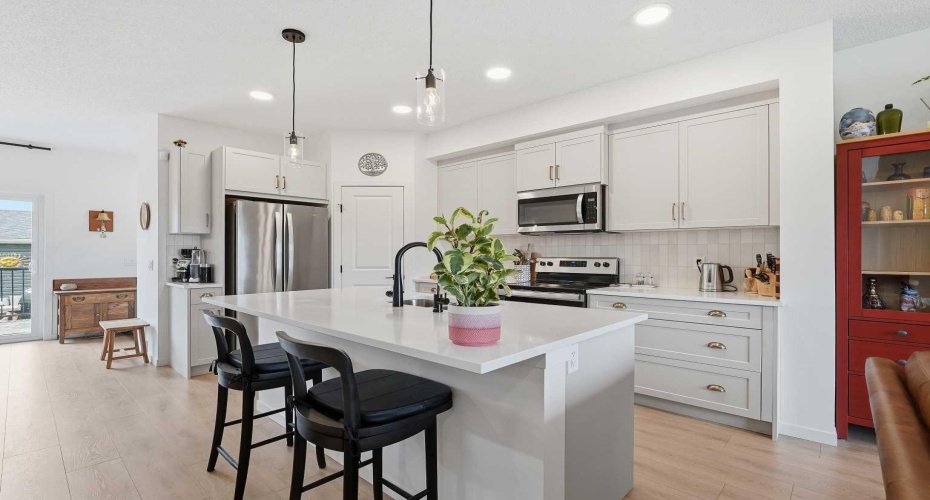 Anchor kitchen with large island, white quartz counter tops and sit up breakfast bar