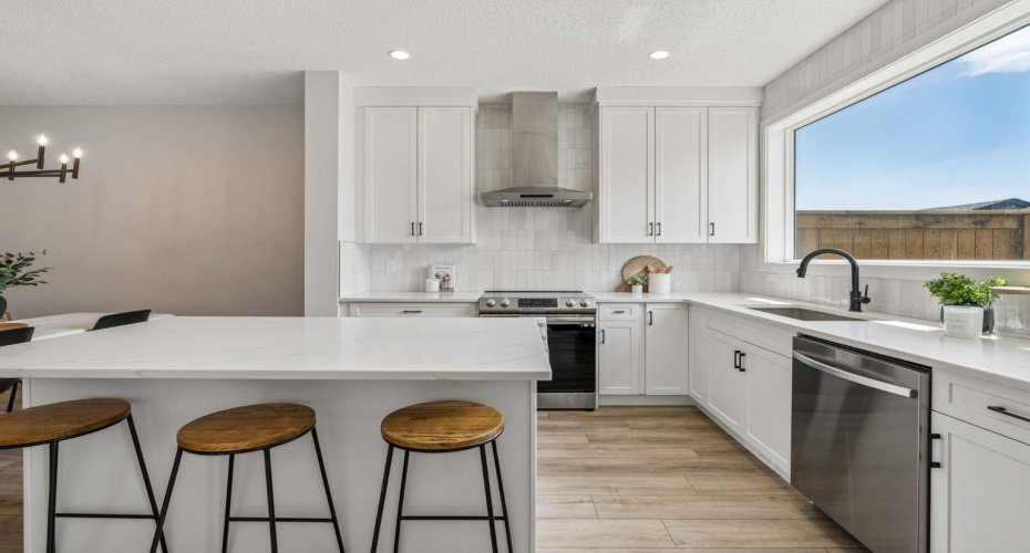 Whether you're preparing family meals or hosting friends, the oversized quartz island provides the perfect gathering space, complemented by timeless finishes, abundant cabinetry, and a seamless open-concept layout.