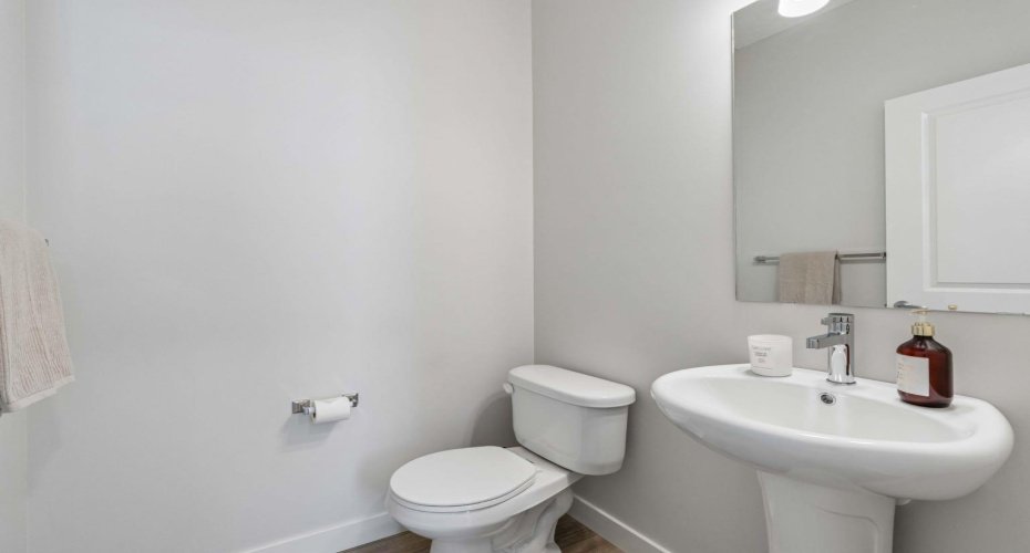 Conveniently located on the main floor, the stylish powder room provides a functional space for family and guests while complementing the home's clean, modern design.